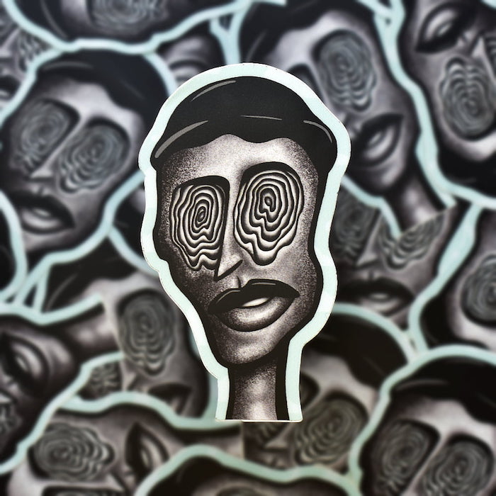 Close-up of the sticker “Pierre”. A surrealist-inspired illustrative portrait of a man. His eyes are a spiral pinwheel design.